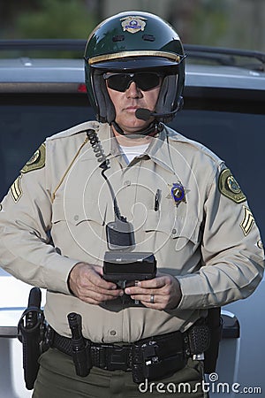 Traffic Cop With Clipboard Standing Against Car