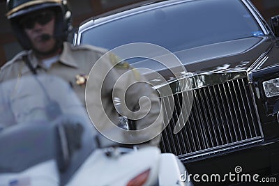 Traffic Cop Sitting On Motorbike With Car In Background