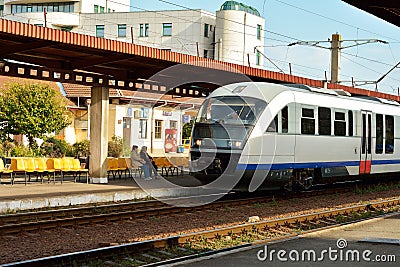 Train in station with people waiting on the waiting seats