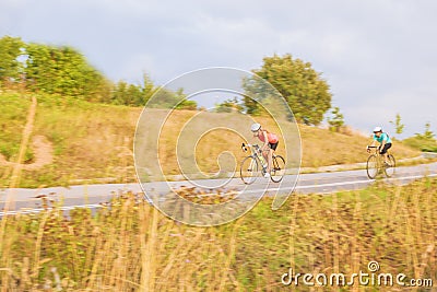 Training process of two female caucasian sportswomen riding bike