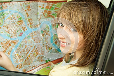 Young woman with road map in car during road trip