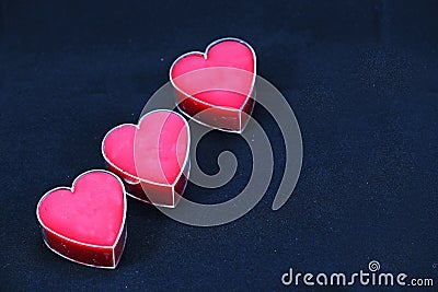 A Trio of Pink Hearts on a Black Background.