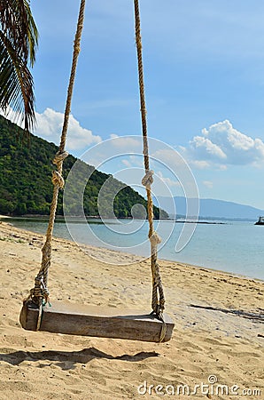 Tropical beach with Old Swing Tied to tree