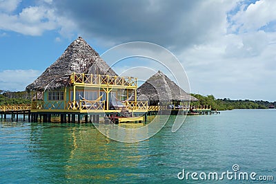 Tropical eco resort over water with thatched roof