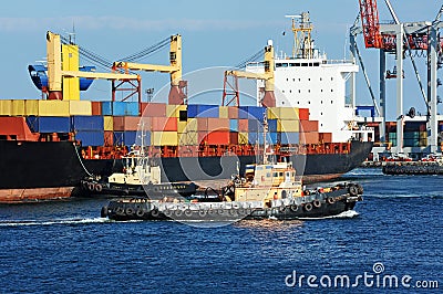 Tugboat assisting container cargo ship