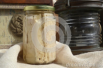Tuna canned in glass jar and maritime motifs