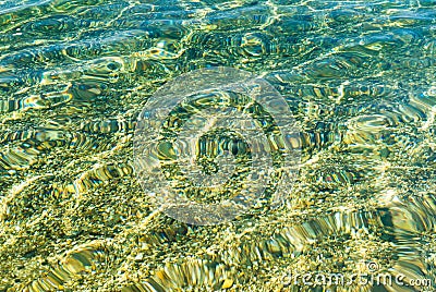 Turquoise water pattern on beach pebbled sand