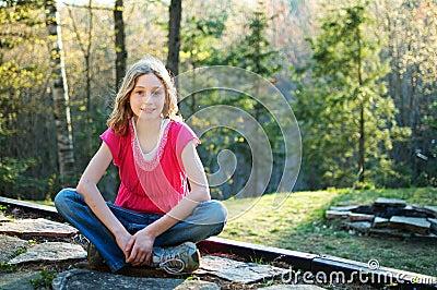 Tween girl sitting cross-legged