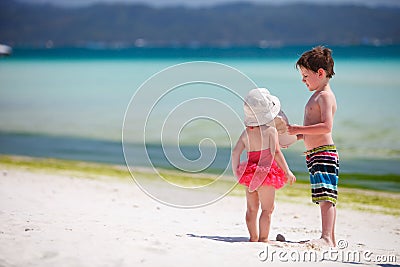 Two adorable kids standing by ocean shore