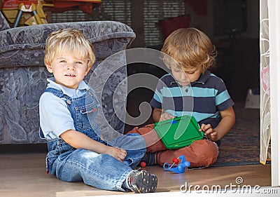 Two adorable little brother boy playing together indoor