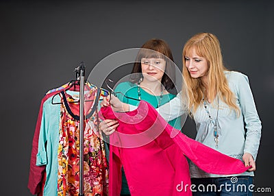 Two beautiful happy women with shopping bags in the clothes store.