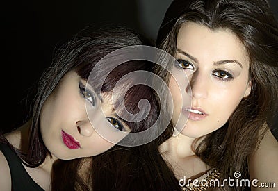 Two beautiful young sensual glamour women standing together over
