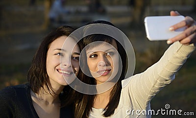 Two Beautiful Young Women Taking Photo