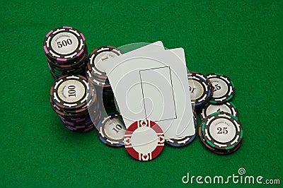 Two blank play cards with stacks of casino chips on green