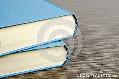 Two blue books on a table with wooden texture