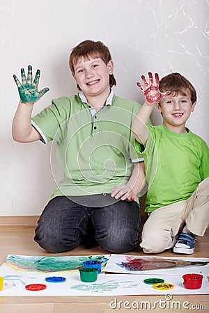 Two boys show right palms smeared with paints