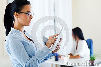 Two business woman working in office with digital tablet.