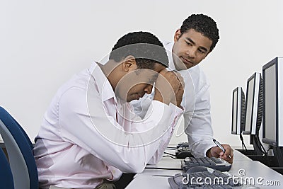 Two Businessmen At Desk In Front Of Computer