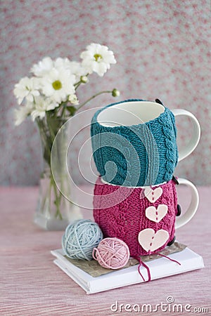Two cups in blue and pink sweater with felt hearts