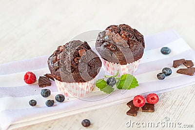 Two delicious homemade chocolate muffins in colored cooking pape