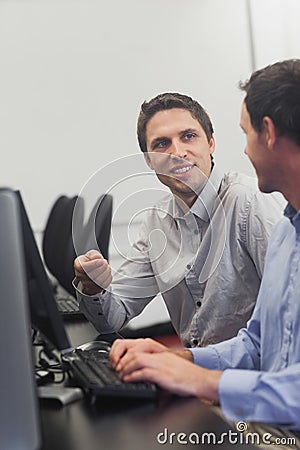 Two friendly men talking sitting in front of a computer