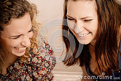 Two girl friends laughing gleefully