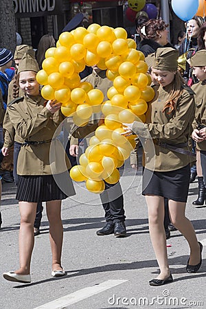 Two girls at the parade with balloons in form of digit nine (the