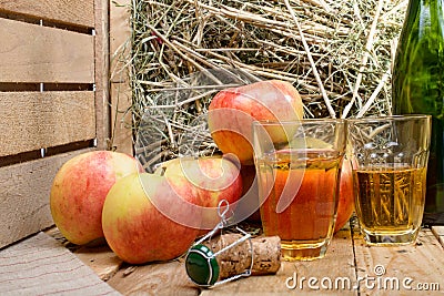 Two glasses of cider with some apples
