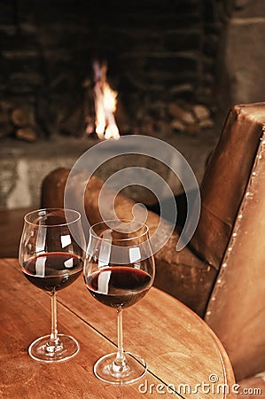 Two Glasses Of Red Wine At A Cosy Fireplace