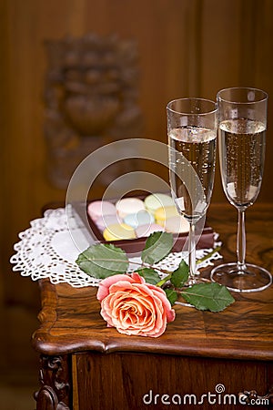 Two glasses of sparkling wine or champagne with small colorful macaroons