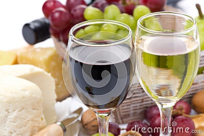 Two glasses with white and red wine, cheese and grapes