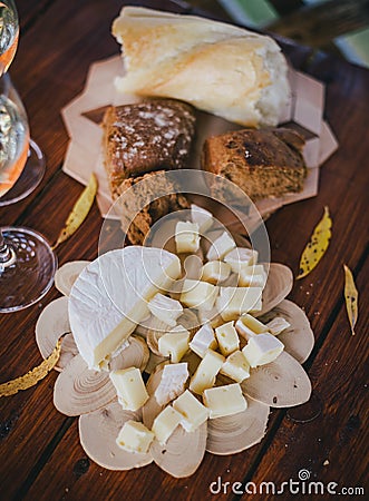 Two glasses of white wine with cheese and bread on a table
