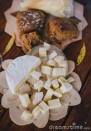 Two glasses of white wine with cheese and bread on a table