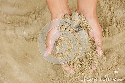 Two hands holding grains of sand