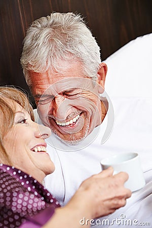 Two happy seniors laughing in bed