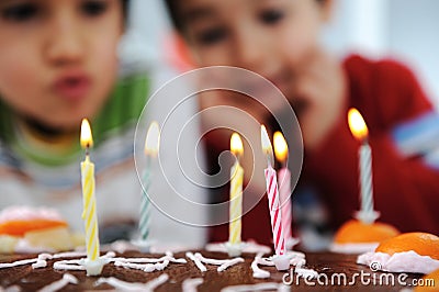 Two little boys blowing candles