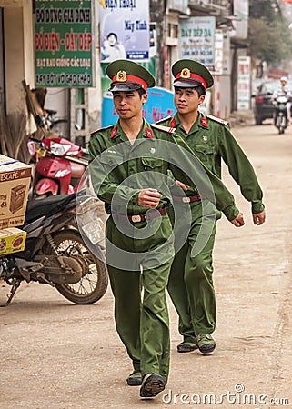Two marching soldiers in the street of rural town.
