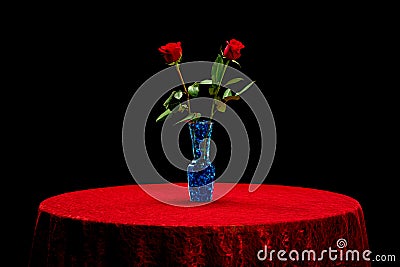 Two roses on a red lace table cloth