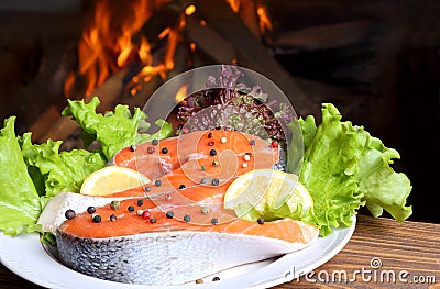 Two salmon steak on the background of a burning flame