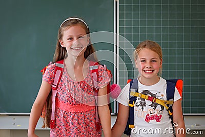 Two schoolgirls in classroom educational concept