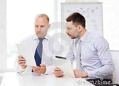 Two serious businessmen with tablet pc in office