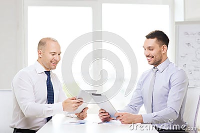 Two smiling businessmen with tablet pc in office