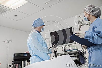 Two surgeons preparing for surgery, patient lying down