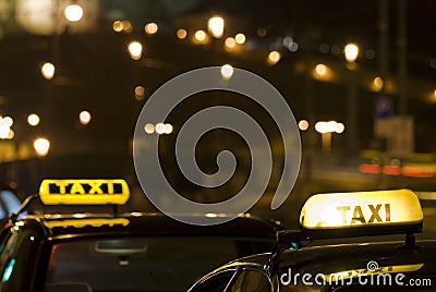 Two taxi signs at night