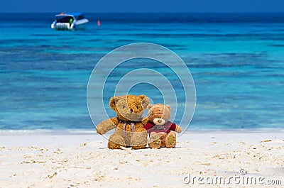 Two TEDDY BEAR brown color sitting on the beautiful beach with b