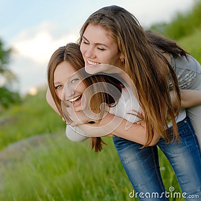 Two Teen Girl Friends Laughing having fun in spring or summer outdoors