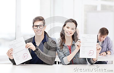 Two teenagers holding test or exam with grade A