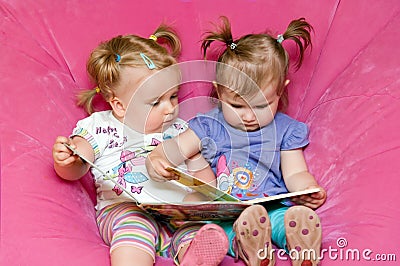 Two toddlers reading together