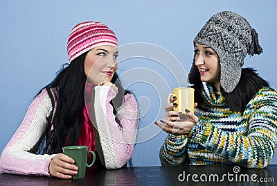 Two women discuss and enjoy a hot drink