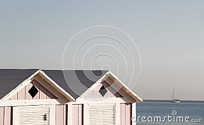 Two wooden bathing boxes and a sailing boat